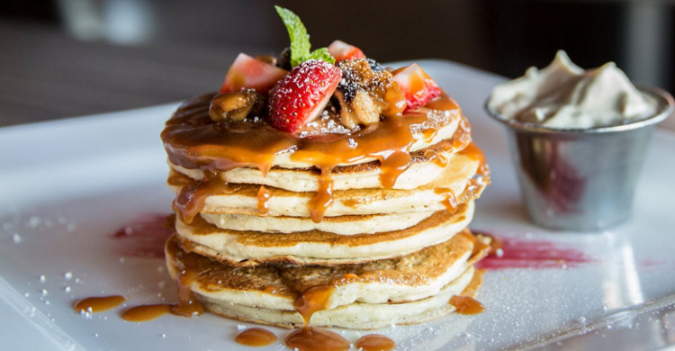 Stack of Pancakes with fruit on top.